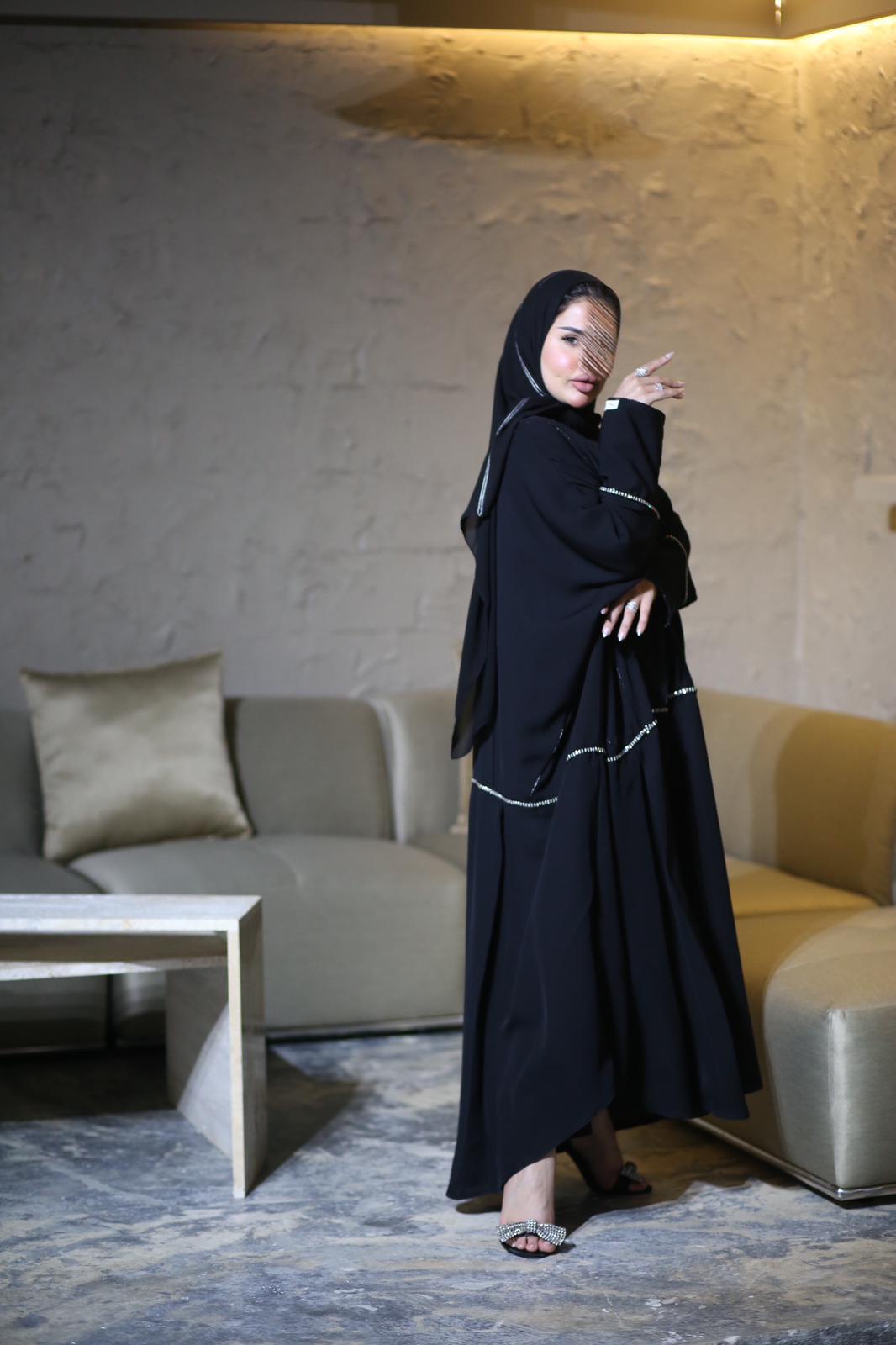 Black abaya with gold line of accessories