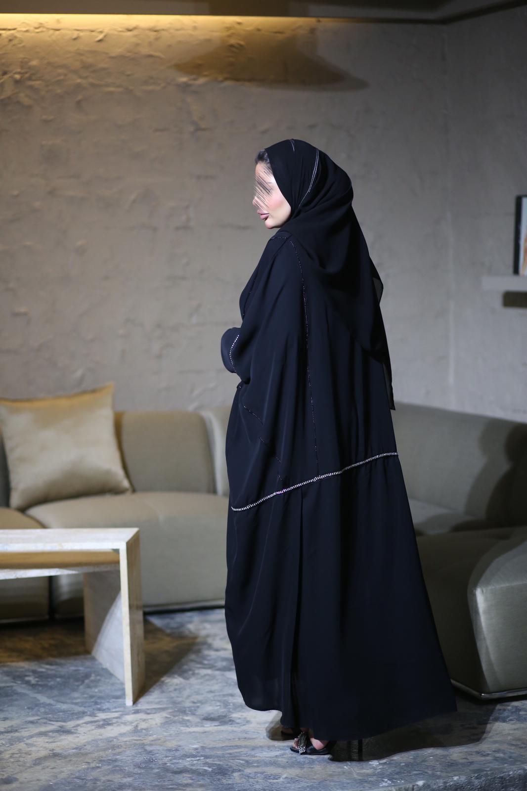 Black abaya with gold line of accessories