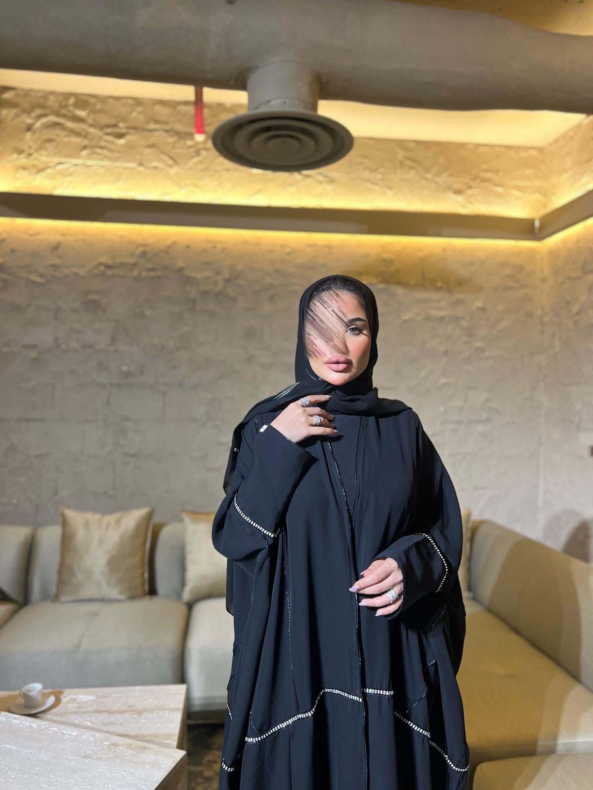 Black abaya with gold line of accessories